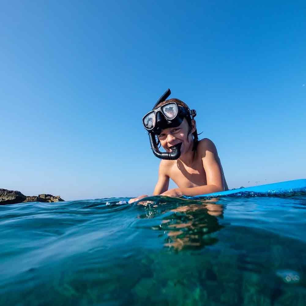 Guests snorkeling in crystal-clear water at Pelican Rock Cabo